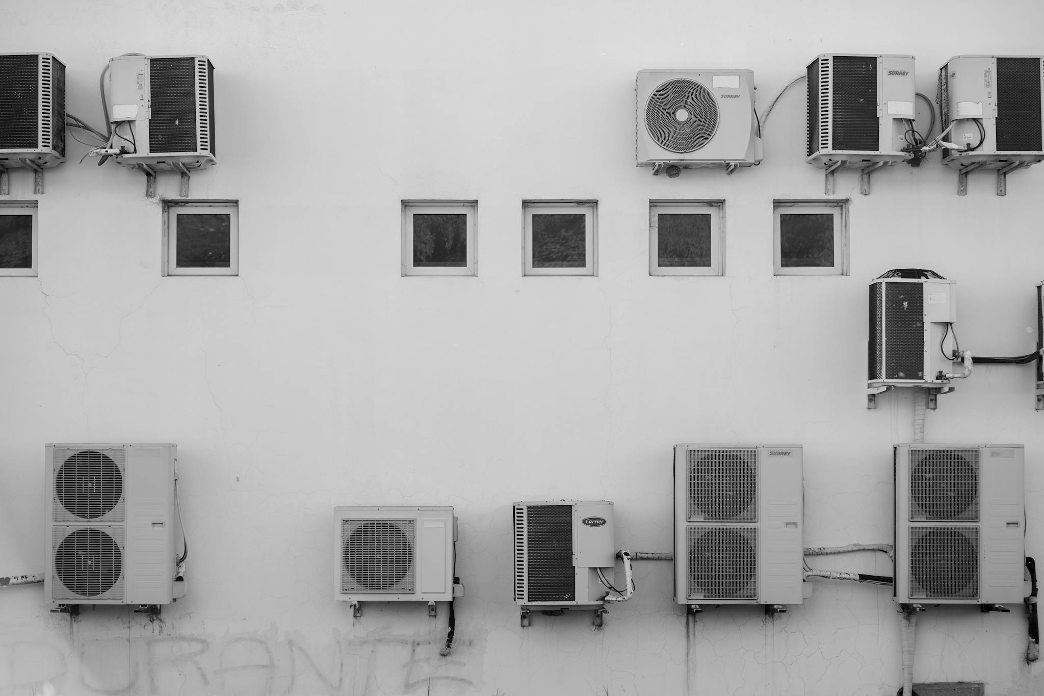 Black and white image of air conditioners mounted on a building facade in Córdoba, Argentina.